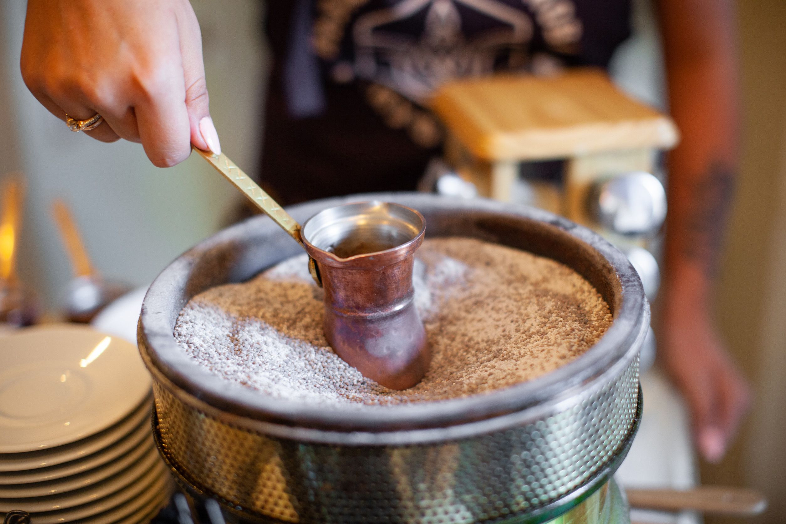 En barista brygger kaffe i en vannkoker