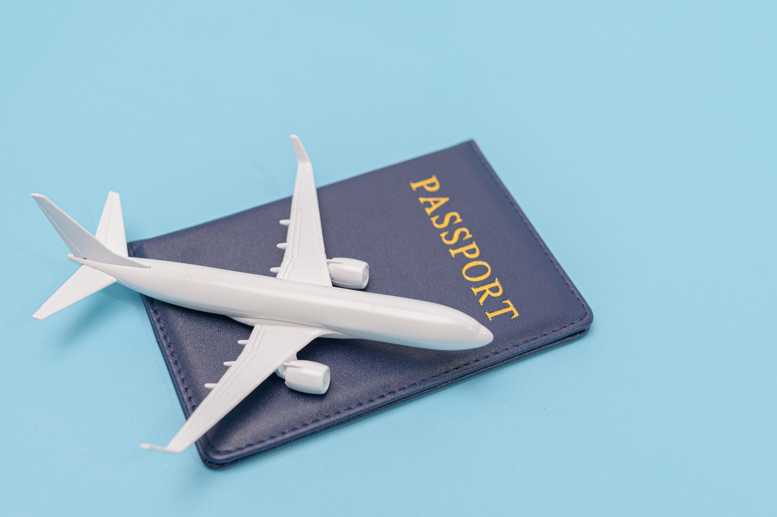 A Miniature Of Aeroplane Lying A Passport