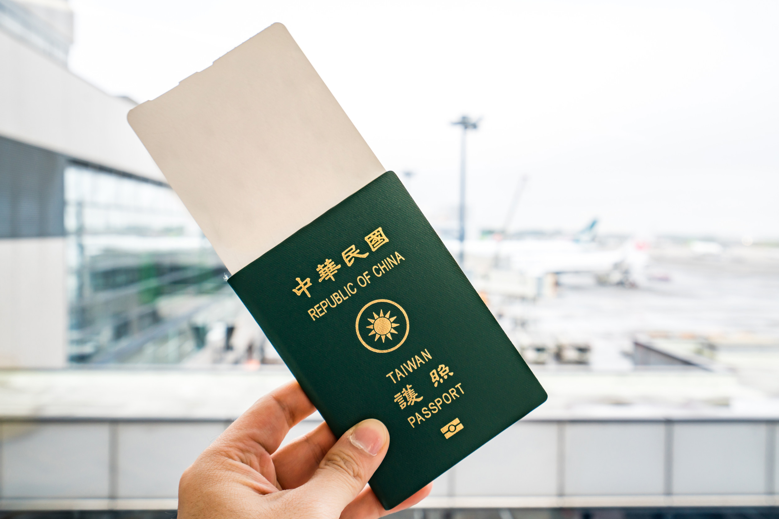 Nærbilde av mann med taiwansk pass og boardingkort på flyplassen