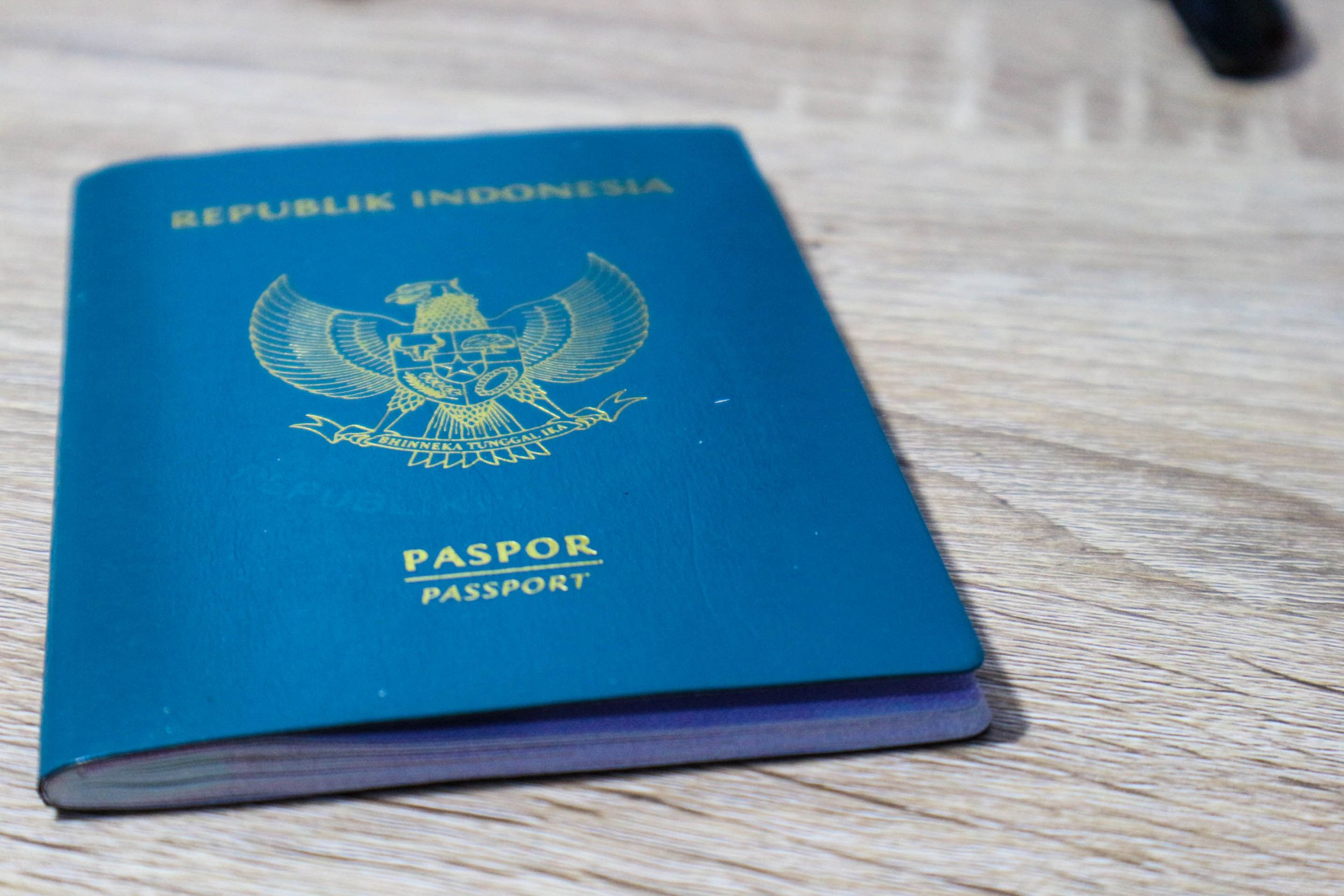 Indonesisk grønt pass på et trebord. Dette passet er en identitet for indonesiske borgere.