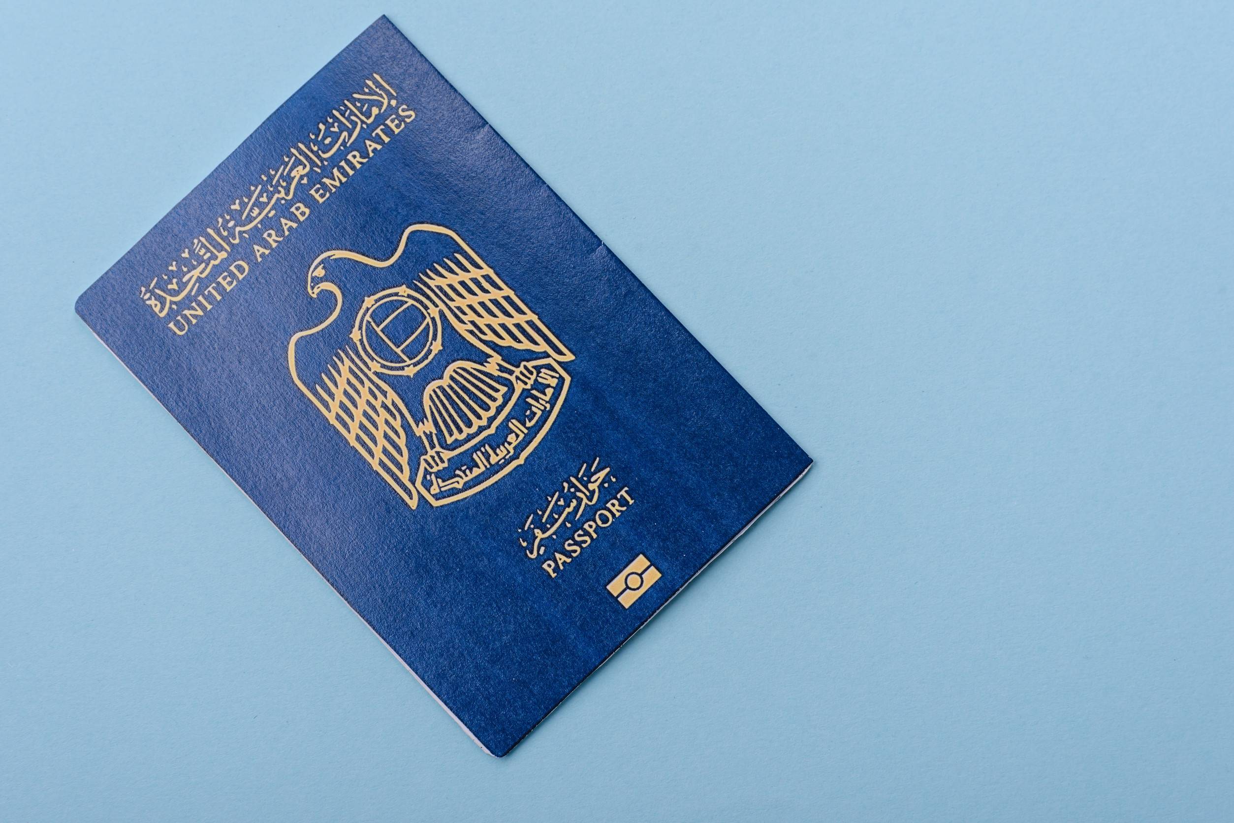 Fysisk papir internasjonalt pass tilhørende en statsborger i De forente arabiske emirater på blå bakgrunn