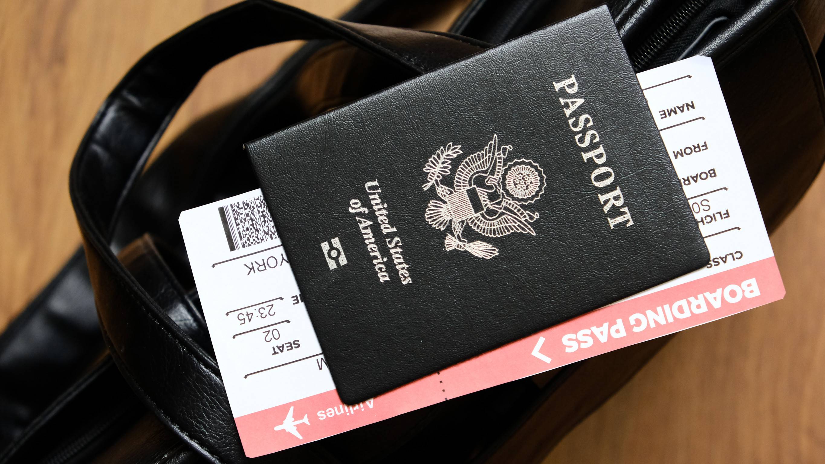 United States Passport And Boarding Pass Are On The Top Of Bag