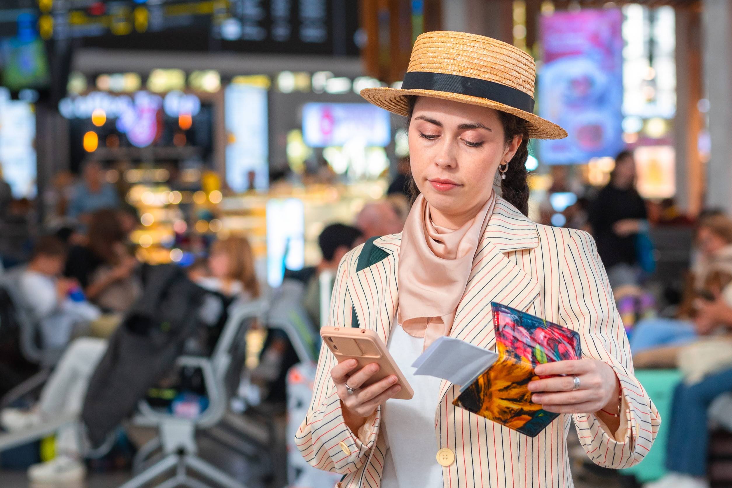 Woman In Straw Hat Holds Passport And Using Smartphone