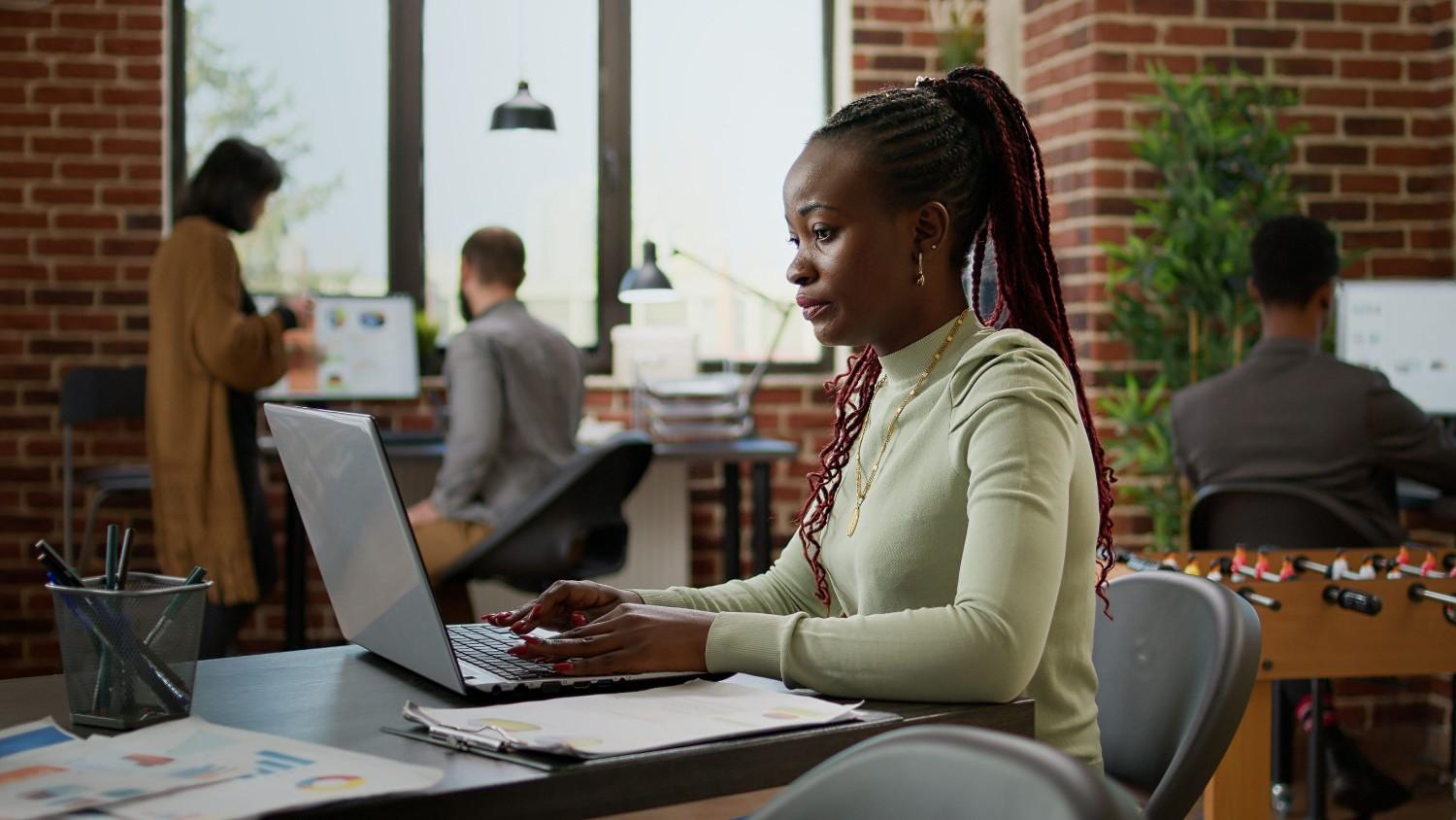 Woman Working at Office Desk with Laptop